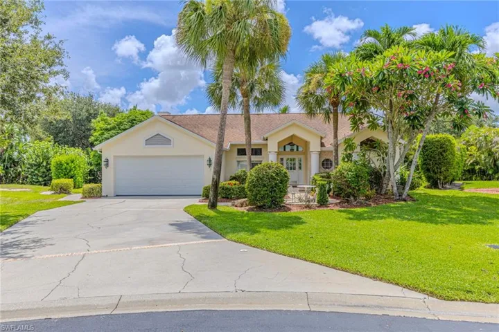 Single-story residence featuring a two-car garage, mature landscaping, and an arched entry