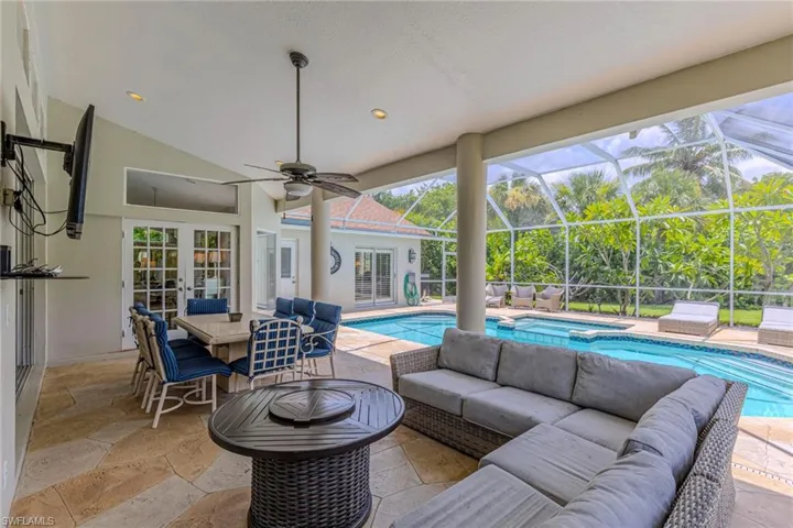 Covered patio with irregular flagstone flooring, a vaulted ceiling, and a ceiling fan