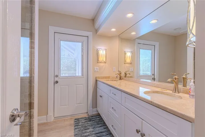 Vanity featuring dual integrated sinks with bronze-finish faucets, expansive countertop, and under-counter storage