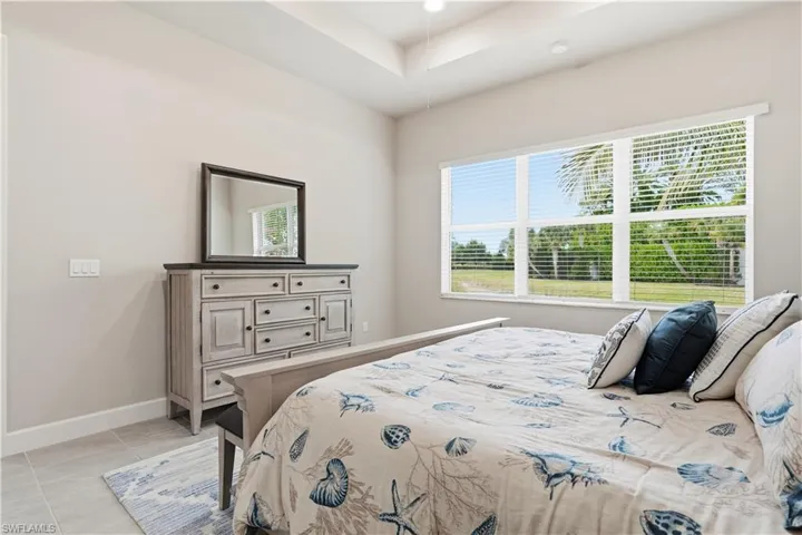 Bedroom featuring a raised ceiling and light tile patterned floors