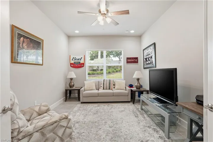 Tiled living area with ceiling fan and recessed lighting