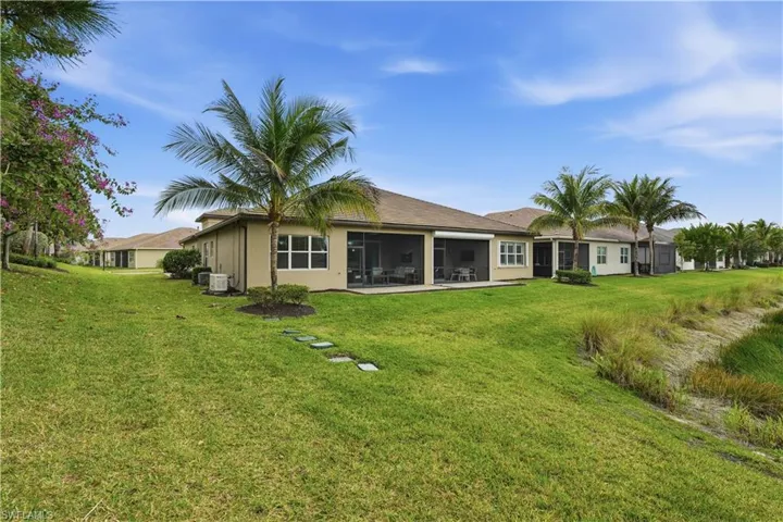 Rear view of house with a sunroom, a yard, and stucco siding
