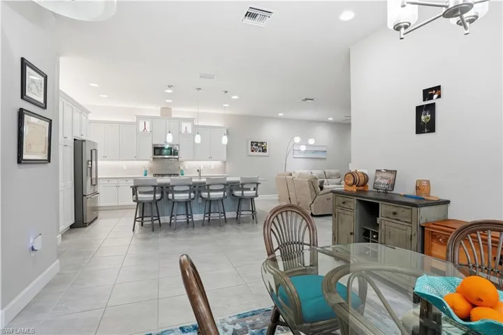 Dining space with light tile patterned floors and recessed lighting
