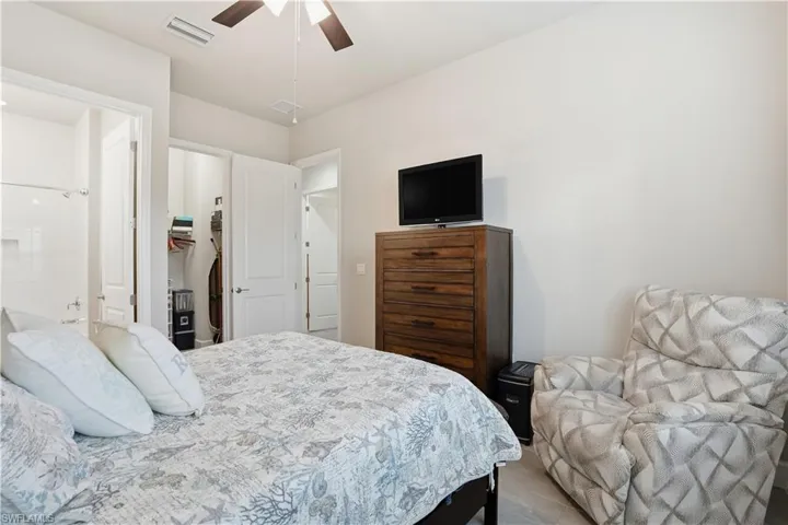 Bedroom with a spacious closet, a ceiling fan, and ensuite bathroom