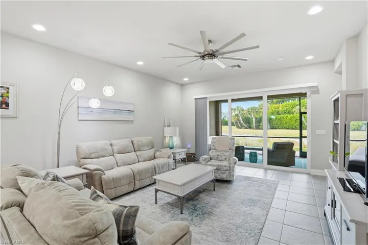 Living room with a ceiling fan, recessed lighting, and light tile patterned flooring