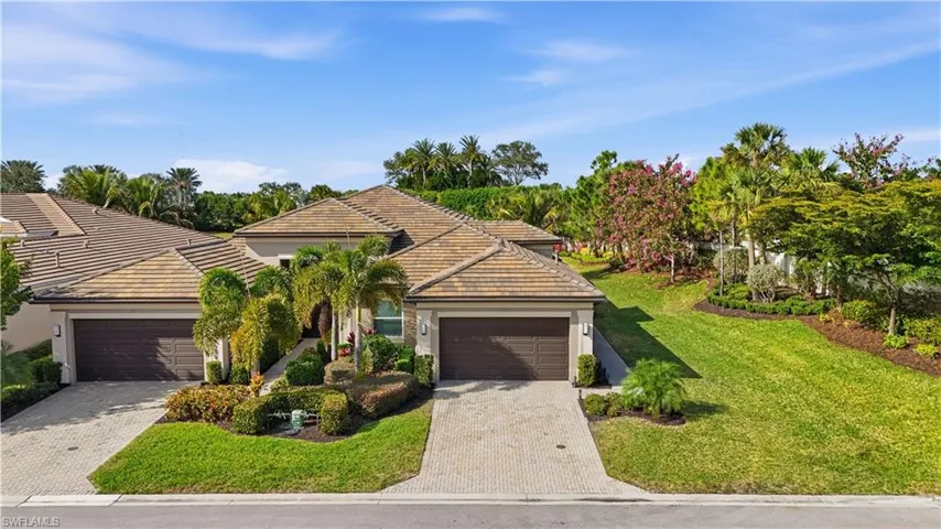 View of front of house with a tiled roof, stucco siding, a garage, and decorative driveway