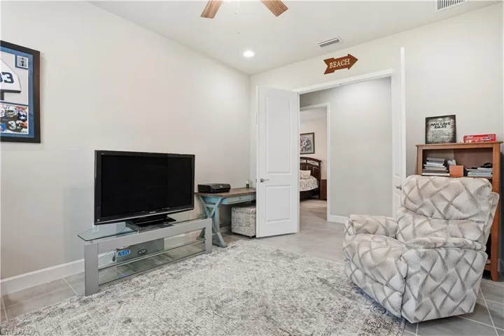 Sitting room featuring light tile patterned flooring, ceiling fan, and recessed lighting