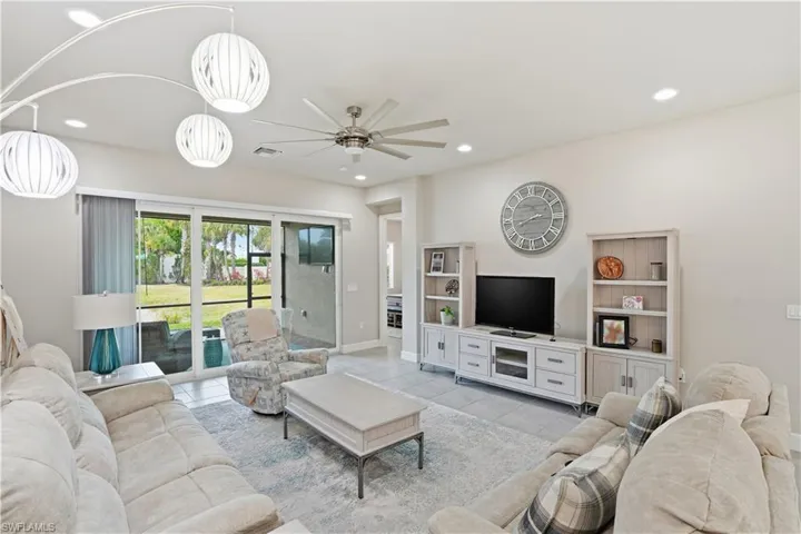 Living room featuring ceiling fan, light tile patterned flooring, and recessed lighting