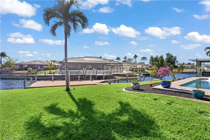 The dock stretches out over the water, framed by lush landscaping that creates a serene and private retreat.