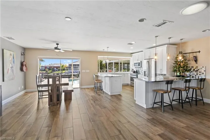 The kitchen and dining area are a true showstopper—featuring crisp white shaker cabinets, upgraded stainless steel appliances, and a spacious island perfect for gathering.