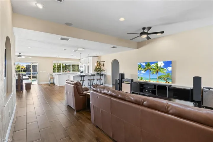 Step into the heart of the home where the living room, dining area, and gourmet kitchen blend into one spacious, light-filled layout—all with sweeping views of the pool and shimmering canal beyond.