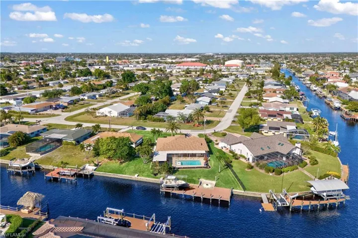 From above, the home stands out with its elegant design, private backyard oasis, and direct access to the canal via a well-built dock.