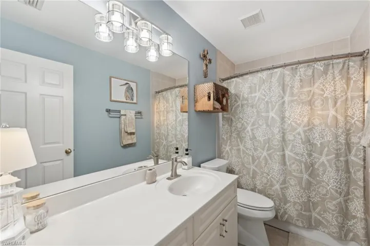 Bathroom with tile patterned floors, a shower with curtain, vanity, and toilet
