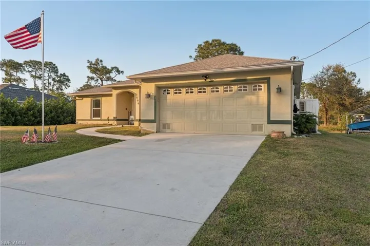 View of front of home with a garage and a front lawn