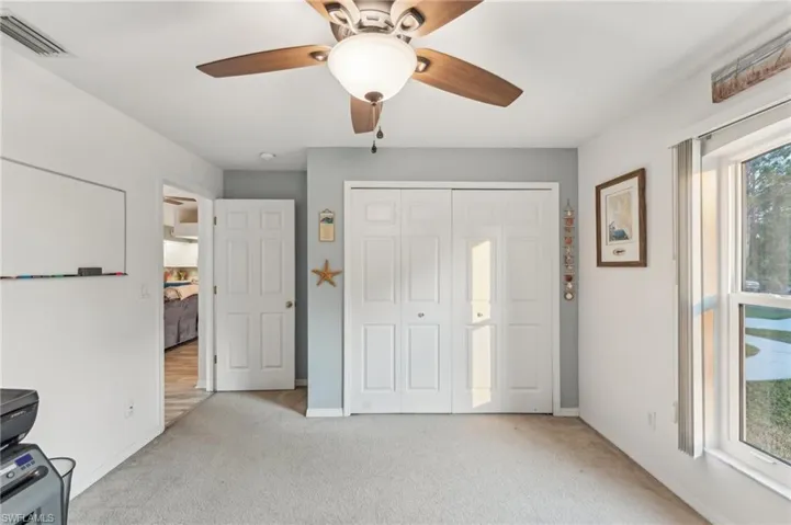 Unfurnished bedroom featuring ceiling fan, light colored carpet, and a closet