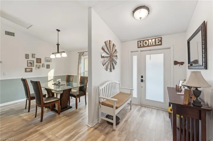 Entryway with light hardwood / wood-style floors and lofted ceiling