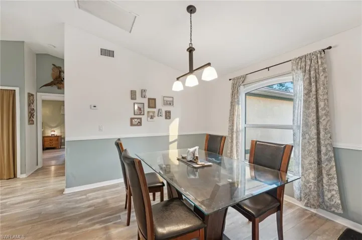 Dining space featuring light hardwood / wood-style flooring and vaulted ceiling