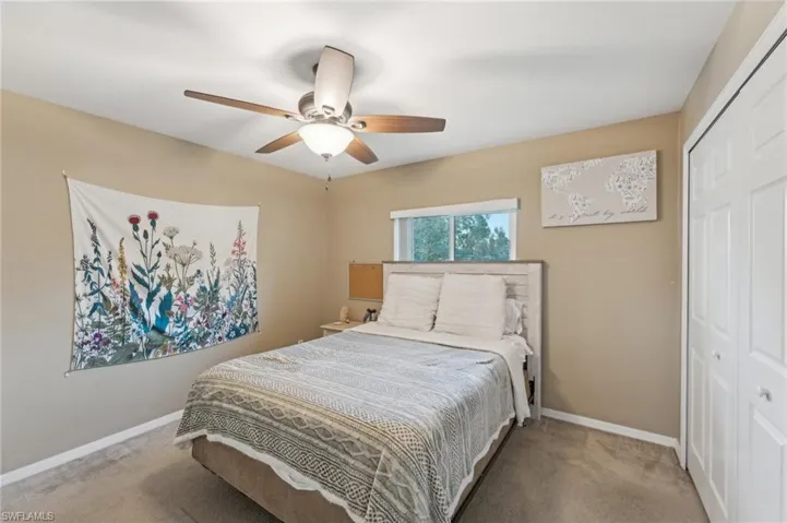 Bedroom with ceiling fan, carpet floors, and a closet