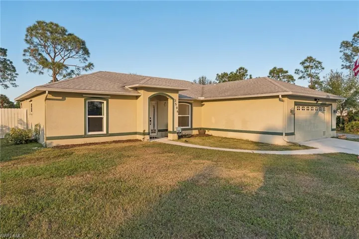 View of front of property with a front yard and a garage