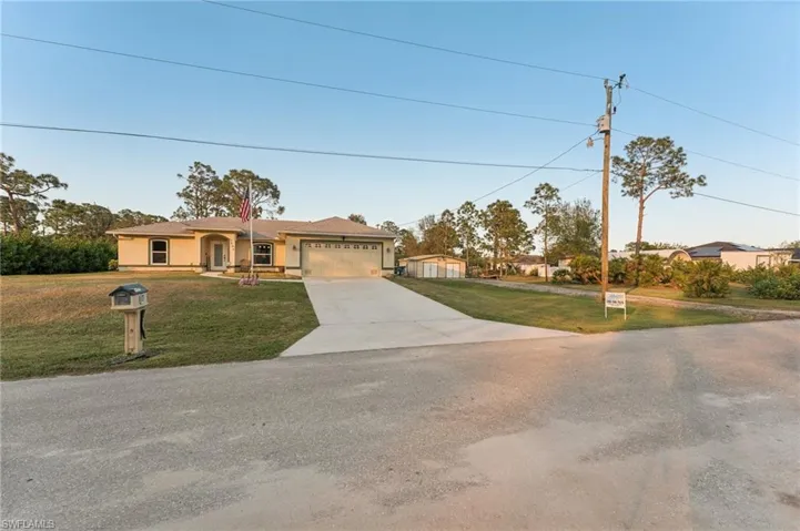 View of front facade featuring a garage and a front lawn