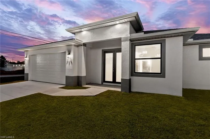 View of front of house featuring a garage and a lawn