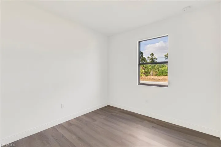 Unfurnished room featuring dark wood-type flooring
