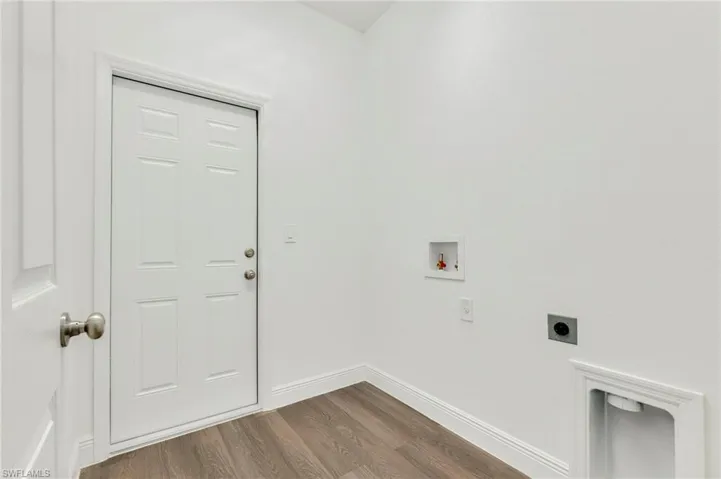 Clothes washing area with electric dryer hookup, hardwood / wood-style floors, and hookup for a washing machine