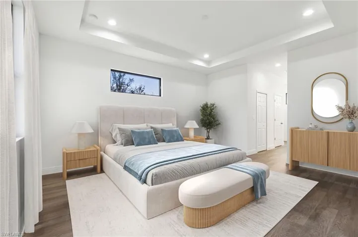 Bedroom featuring dark hardwood / wood-style floors and a tray ceiling
