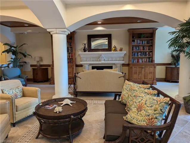 Tiled living room featuring built in features and decorative columns