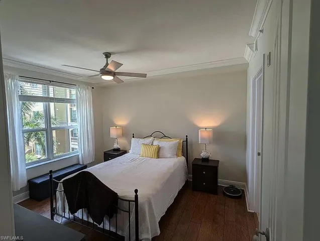 Bedroom with dark hardwood / wood-style floors, ceiling fan, and ornamental molding