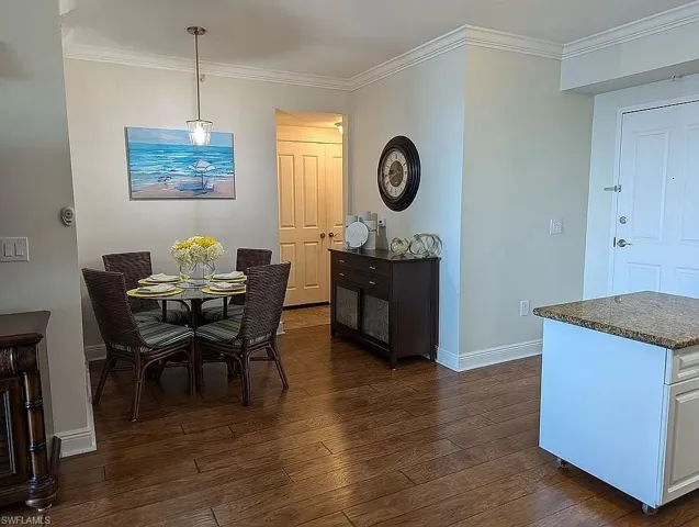 Dining room featuring dark wood-type flooring and ornamental molding