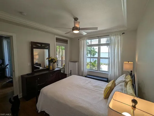 Bedroom featuring crown molding, dark hardwood / wood-style flooring, and ceiling fan