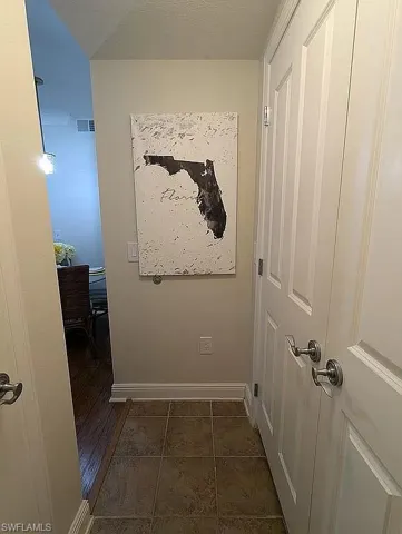 Hall featuring dark tile patterned floors