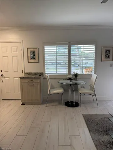 Dining area featuring ceramic tiled floors and crown molding.  Plantation shutters and lots of light