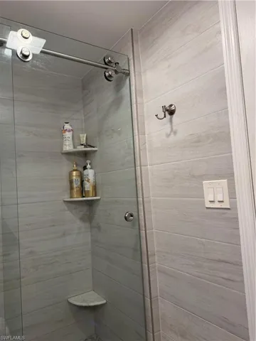 Bathroom with a stall shower with custom doors.  Floor to ceiling tile