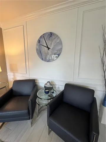 Sitting area with a decorative wall and light wood ceramic flooring