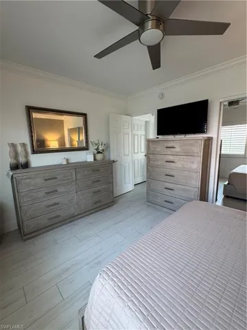 Bedroom with ceiling fan, crown molding, and light wood-style ceramic floors