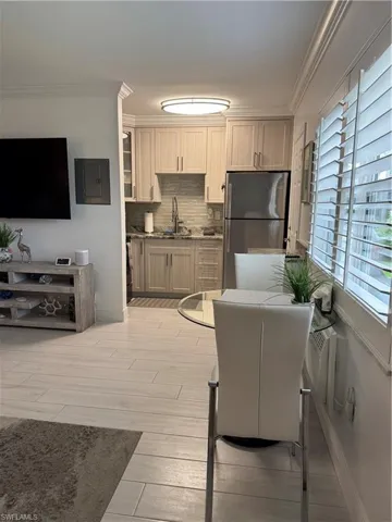 Kitchen featuring crown molding, fridge, light wood-type flooring, and granite stone counters
