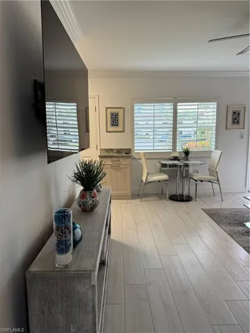 Dining area with crown molding, light finished ceramic floors, and ceiling fan