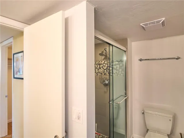 Bathroom with a shower stall and toilet