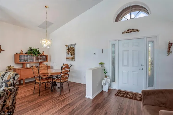 Entryway with high vaulted ceiling, dark hardwood / wood-style floors, and an inviting chandelier