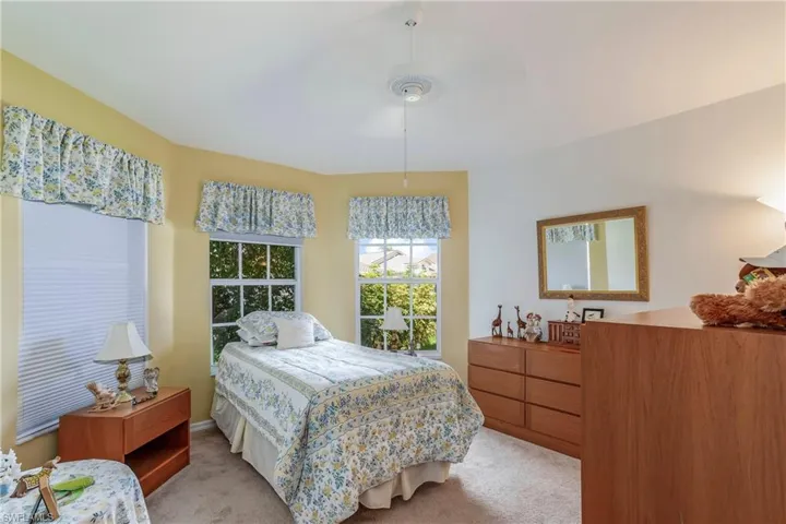 Bedroom with ceiling fan and light colored carpet