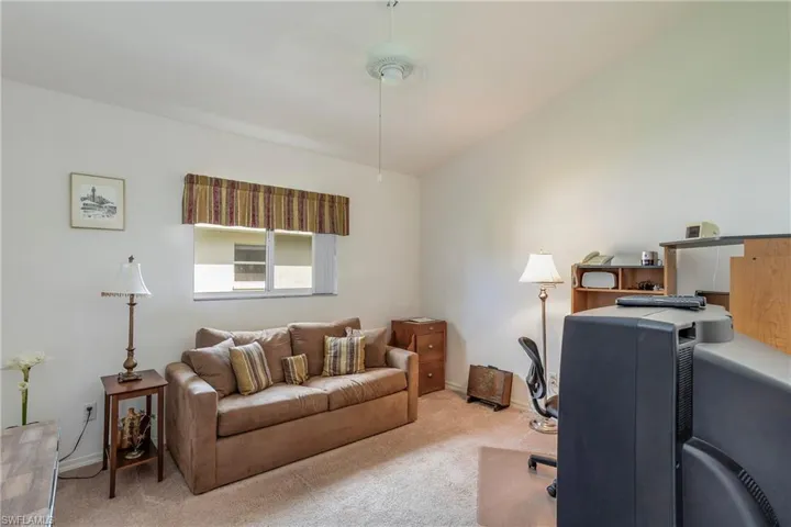 Office featuring vaulted ceiling and light carpet