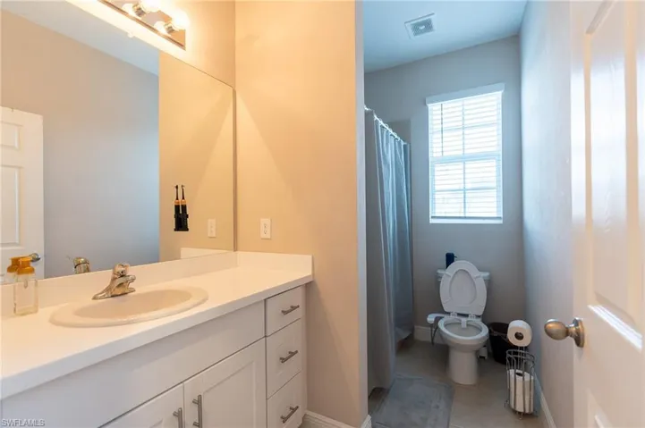 Full bath featuring vanity, a shower with shower curtain, and light tile patterned floors