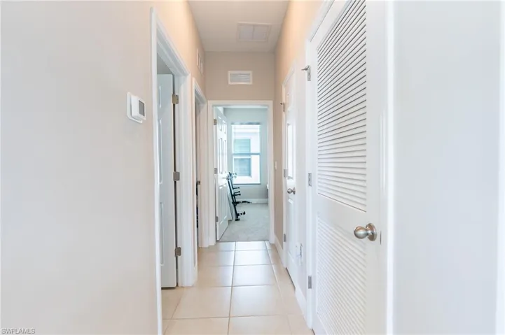 Corridor featuring light tile patterned flooring and baseboards