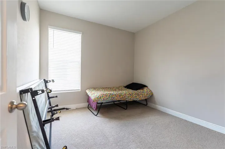 Bedroom with light colored carpet and baseboards