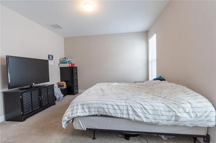 Bedroom with light carpet and baseboards