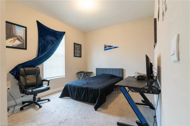 Bedroom featuring carpet and a desk