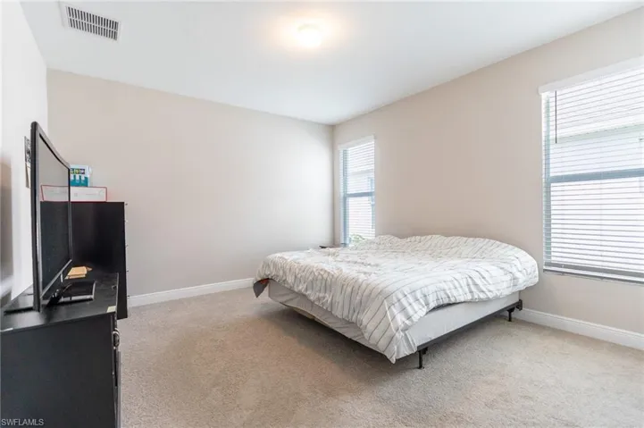 Bedroom featuring light carpet