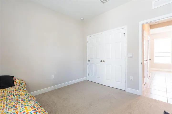 Unfurnished bedroom with light colored carpet and a closet